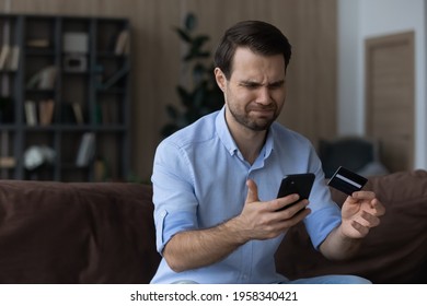 Unhappy millennial Caucasian man frustrated by error mistake paying online on smartphone with credit card. Mad young male client or customer confused with unsuccessful internet payment on cellphone.