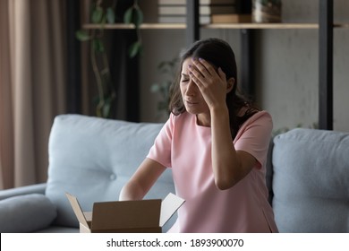 Unhappy Millennial Indian Arabic Woman Displeased With Wrong Order Unpacking Box Shopping Online. Upset Young Ethnic Female Client Or Customer Dissatisfied With Bad Quality Product Unboxing At Home.