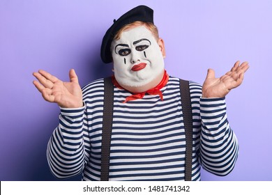 unhappy mime showing shrug gesture isolated on blue, body language, isolated blue background. indifference, apathy