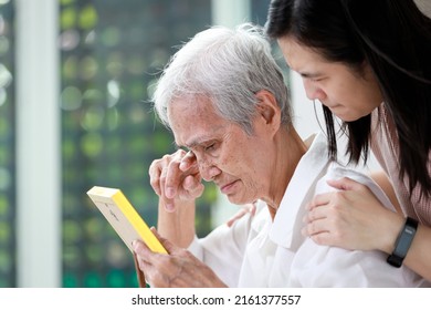 Unhappy old elderly grandmother crying tears looking at photograph of family with  sorrow,sad asian senior people holding photo frame of her deceased husband,a feeling of deep distress caused by loss