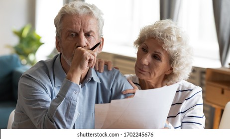 Unhappy Older Couple Reading Documents, Checking Domestic Bills, Caring Mature Wife Comforting Sad Upset Husband Holding Debt Notification, Stressed About Financial Problem Or Bankruptcy