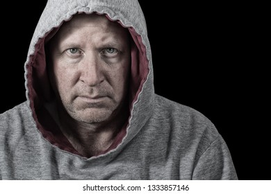 Unhappy And Perhaps Angry Man In Hoodie. Isolated On Black.