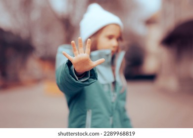 
				Unhappy Preschool Little Girl Making a Stop Bullying Gesture. Desperate bullied child defending herself making halt sign
				