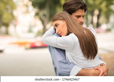 Unhappy Relationship. Sad Guy And Girl Hugging Feeling Unloved And Stuck In Relations Standing In Park Outdoors. Copy Space