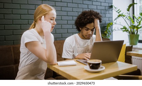 Unhappy Restaurant Workers Looking At Laptop, Upset With Financial Problems