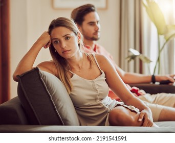 Unhappy, sad and annoyed couple after a fight and are angry at each other while sitting on a couch at home. A woman is stressed, upset and frustrated by her boyfriend after an argument - Shutterstock ID 2191541591