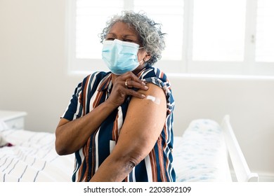 Unhappy Senior African American Woman Wearing Face Mask With Plaster On Arm After Vaccination. Senior Health And Lifestyle During Covid 19 Pandemic.