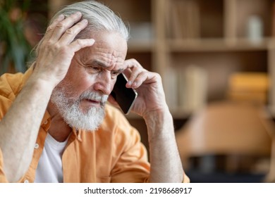 Unhappy senior man having phone conversation with someone, touching his head and looking down, upset grandfather getting bad news, home interior, copy space, closeup shot - Powered by Shutterstock