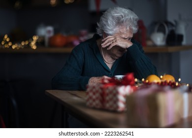 Unhappy senior woman sitting alone and crying during Christmas Eve.Concept of solitude senior and mental health.