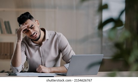 Unhappy shocked arabian male worker look at laptop screen feeling nervous upset with bad news problems study failure exam frustrated young man confused unexpected error on computer losing online bets 