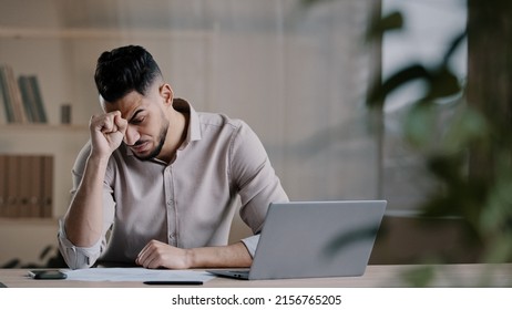 Unhappy shocked arabian male worker look at laptop screen feeling nervous upset with bad news problems study failure exam frustrated young man confused unexpected error on computer losing online bets