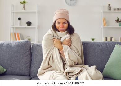 Unhappy Sick Woman In Hat And Blanket Suffering From Cold At Home, Looking At Camera, Freezing, Complaining To EHealth Doctor Via Skype, Zoom Or FaceTime Video Call, Telling About Flu Fever Symptoms