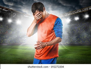 unhappy soccer or football player with palm on his face on stadium