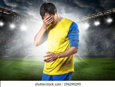 unhappy soccer or football player with palm on his face on stadium