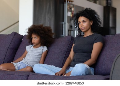 Unhappy Sulky African Child Girl And Annoyed Mother Sitting On Sofa Not Talking After Fight, Stubborn Mixed Race Kid Daughter And Mom Ignore Each Other Upset By Quarrel, Black Family Conflict Concept