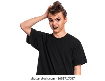 Unhappy Teen Boy Student In Style Of Punk Goth Dressed In Black T-shirt, Isolated On White Background. Upset Teenager Back To School. Sad Or Thoughtful Child With Spooking Makeup Looks At Camera.