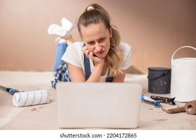 Unhappy Teenage Girl Sitting In Front Of A Laptop And Not Wanting To Study Online. She Has Just Started Renovating Her Dorm Room