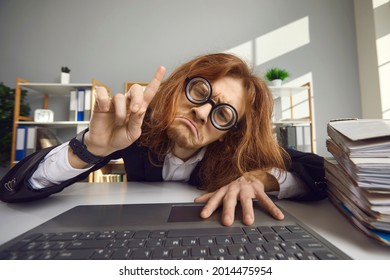 Unhappy tired man stuck at work and can't go home. Desperate employee sitting chained to laptop computer and crying. Office slavery, nine to five job, technology addiction, working extra hours concept - Shutterstock ID 2014475954
