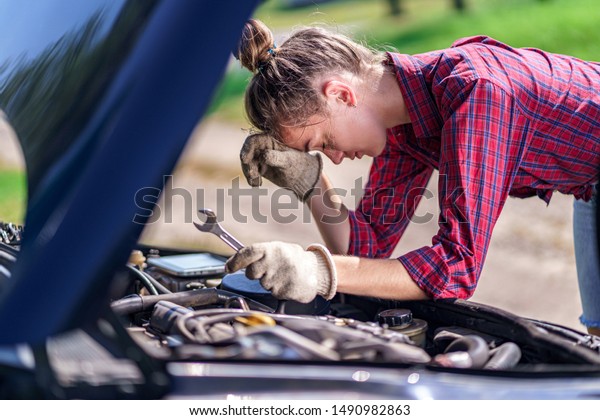 Unhappy upset stressed woman driver having trouble\
with broken car during a trip. Need for service and repair car for\
failed engine