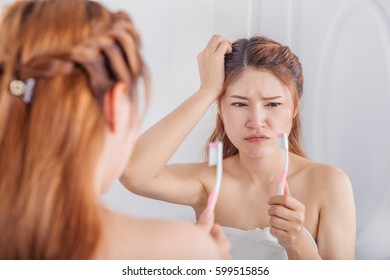 unhappy woman in bath towel brushing teeth with mirror in the bathroom - Shutterstock ID 599515856