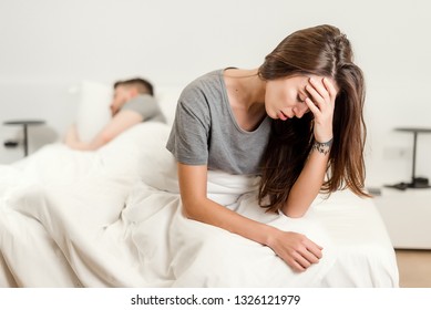 Unhappy Woman In Bed With A Sleeping Man. Relationship And Sexual Problems Concept