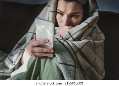 Unhappy woman in bed under plaid with smartphone, following ex-boyfriend on social media, sad female using mobile phone at night, suffering from insomnia. Anxiety. Woman surfing bad news in smartphone - Shutterstock ID 2155913803
