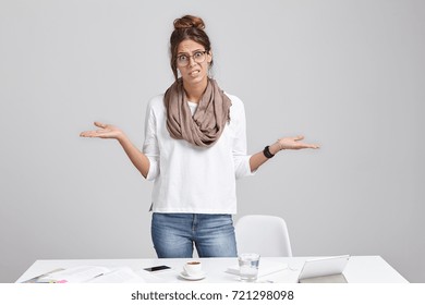 Unhappy Woman Frowns Face In Displaesure, Shrug Shoulders, Has Bad Mood, Stands At Office Table, Makes Mistake In Annual Report, Should Do Calculation From Beginning, Look Desperatedly And Upset