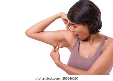unhappy woman with hand holding excessive arm fat, isolated on white background