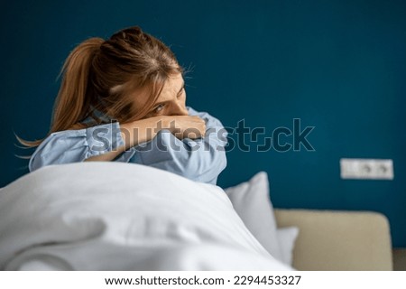 Unhappy woman having depressive mood, sitting on bed looking aside, feeling sadness and loss of interest in everything. Depressed female coping with grief. Mental illnesses concept