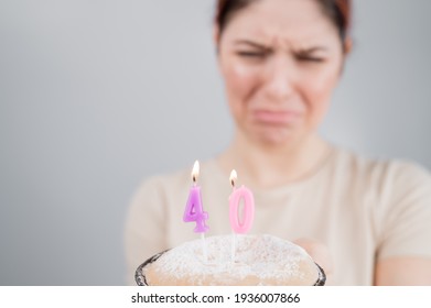 Unhappy Woman Holding A Cake With Candles For Her 40th Birthday. The Girl Cries About The Loss Of Youth.