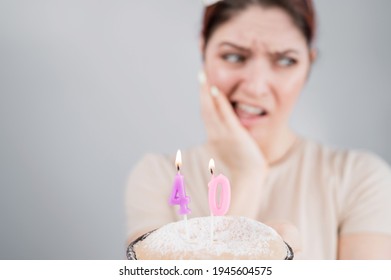 Unhappy Woman Holding A Cake With Candles For Her 40th Birthday. The Girl Cries About The Loss Of Youth.