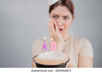 Unhappy Woman Holding A Cake With Candles For Her 40th Birthday. The Girl Cries About The Loss Of Youth.