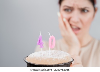 Unhappy Woman Holding A Cake With Candles For Her 40th Birthday. The Girl Cries About The Loss Of Youth.