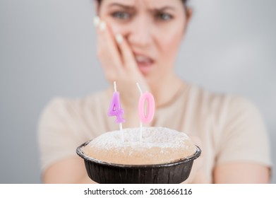 Unhappy Woman Holding A Cake With Candles For Her 40th Birthday. The Girl Cries About The Loss Of Youth.