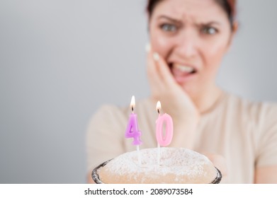 Unhappy Woman Holding A Cake With Candles For Her 40th Birthday. The Girl Cries About The Loss Of Youth.