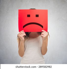 Unhappy Woman Holding A Sad Emoticon In Front Of His Face