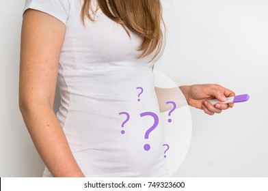 Unhappy woman with imagination of a pregnant belly holding negative pregnancy test - infertility concept
