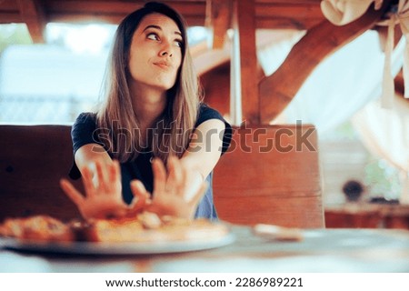 
Unhappy Woman refusing to Eat her Pizza Dish in a Restaurant. Disgruntled customer not liking the meal sending it back
