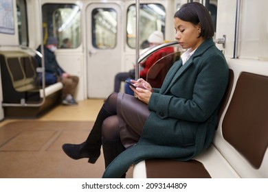 Unhappy Woman Scrolling Social Media Riding In Subway Home From Work. Tired Upset Businesswoman Return From Office Spend Time Messaging Or Browsing Web In Metro Carriage Transport With 5g Internet