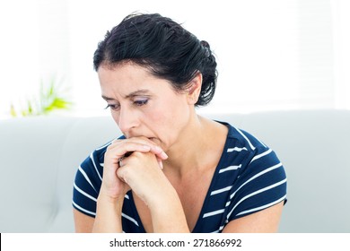 Unhappy Woman Sitting On The Couch On White Background