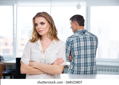 Unhappy woman standing with arms crossed in quarrel with her husband at home - Powered by Shutterstock