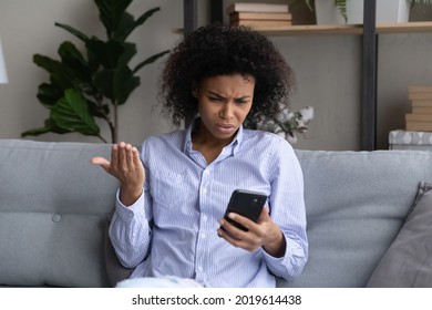 Unhappy young African American woman look at smartphone screen confused by error or mistake online on device. Upset biracial female use gadget feel distressed with bad negative news on cellphone. - Powered by Shutterstock