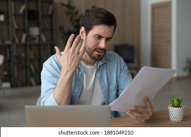 Unhappy young Caucasian man feel distressed frustrated by bad news in post letter correspondence. Upset millennial male confused stressed with negative response or dismissal notice in paperwork.