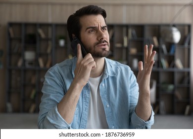 Unhappy young Caucasian man talk speak on smartphone distressed with negative response online. Stressed upset male have cellphone call, feel frustrated disappointed with bad news or message. - Powered by Shutterstock