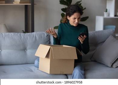 Unhappy young Caucasian woman look at cellphone screen dissatisfied with online order shopping on internet. Upset female use smartphone unpack box get wrong or damaged packaged. Bad delivery concept.