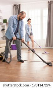 Unhappy Young Couple Cleaning Living Room Floor.