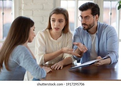 Unhappy young family couple clients feeling stressed with bad contract offer, showing dissatisfaction to broker or dealer. Angry millennial spouses arguing with real estate agent at office meeting.