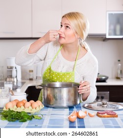 Unhappy Young Housewife Preparing Exotic Food With Rank Odour At Kitchen