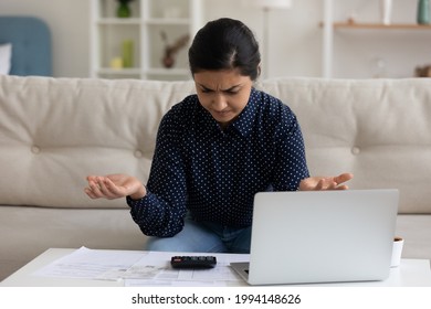 Unhappy Young Indian Woman Confused By Debt Or Bankruptcy Paying Bills Taxes Online On Computer At Home. Mad Mixed Race Female Frustrated By Financial Bank Problems Managing Budget On Laptop.