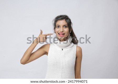 unhappy young Pakistani girl pointing a finger on her tongue